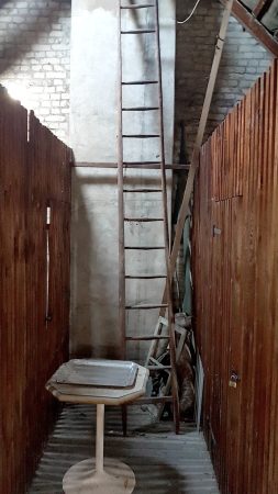 Ein Dachboden Gang mit einer Leiter vor einer Entrümpelung