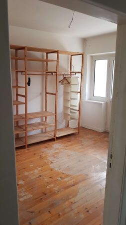 Wohnzimmer mit einer anderen Perspektive auf ein Regal während einer Haushaltsauflösung